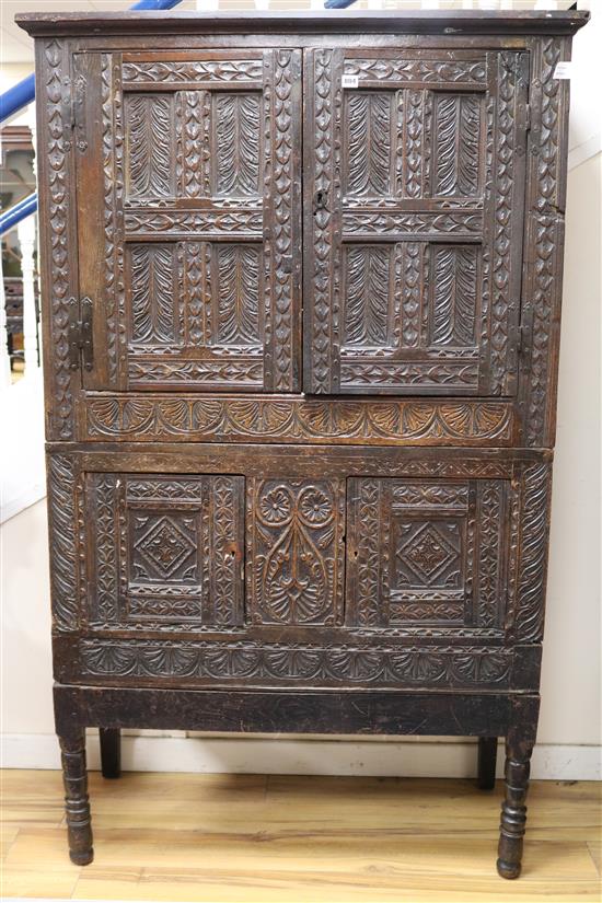 An 18th century carved oak cupboard W.112cm